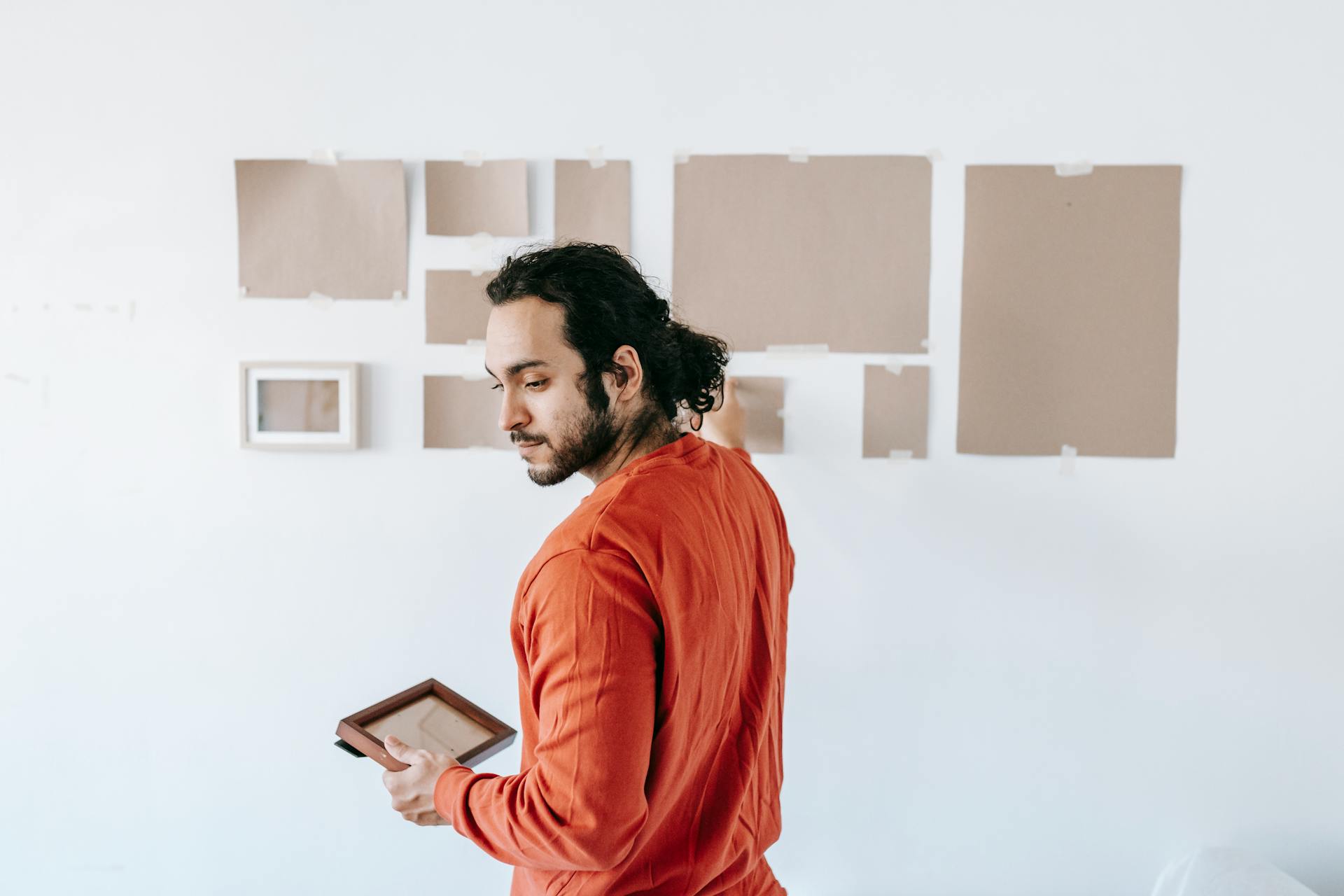 A Guy is setting up a picture wall