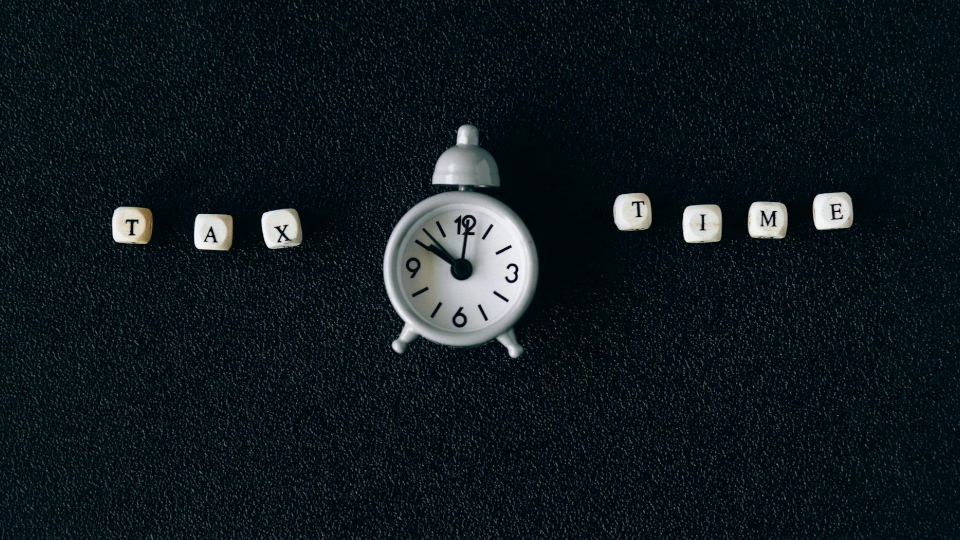 little blocks spelling "tax time" against a textured black background